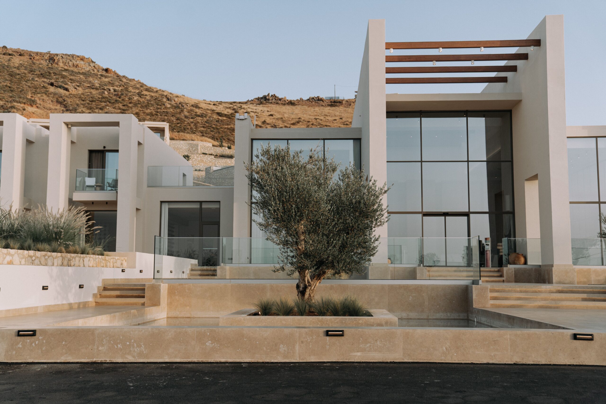 Contemporary hillside home with stucco walls, glass, and desert landscaping